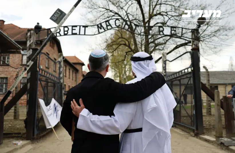 Eitan Neishlos standing in front of the gates to Auscwhitz with Ahmed Obaid AlMansoori