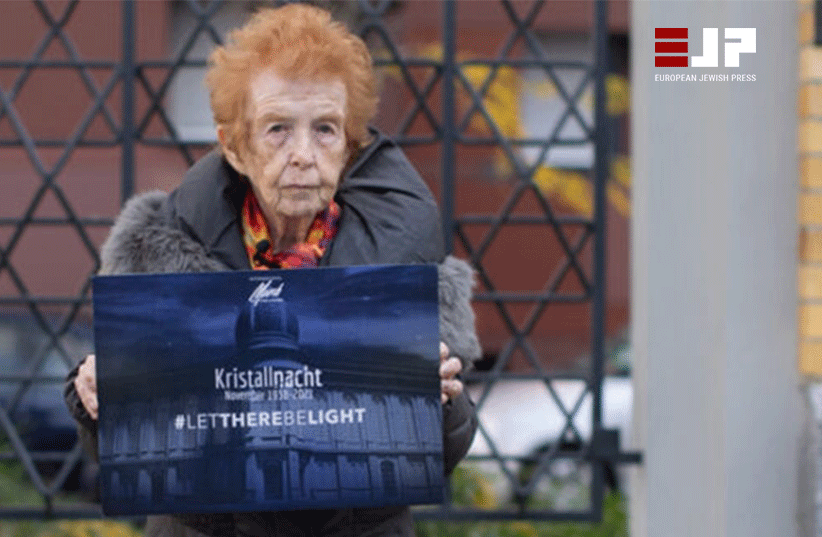 Neishlos, Holocaust survivor Eve Kugler holding a signle for Kristallnacht